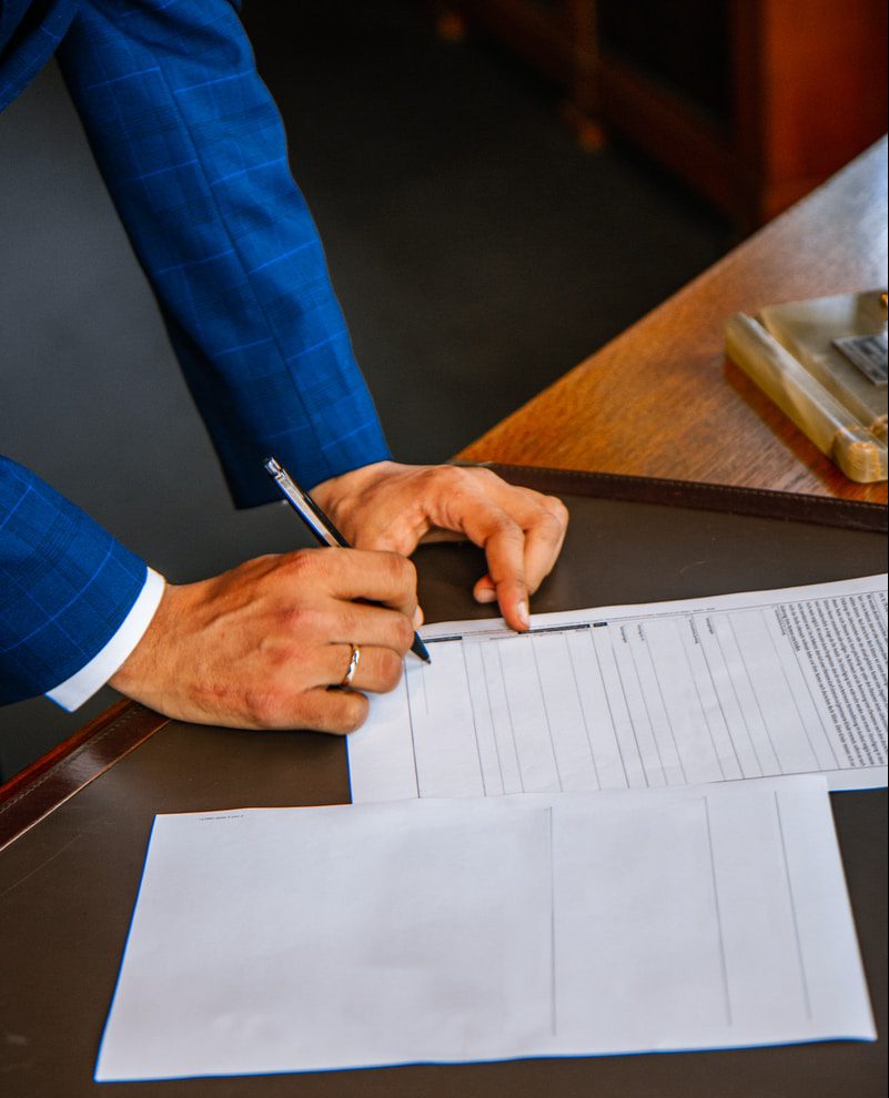 person writing on white form paper